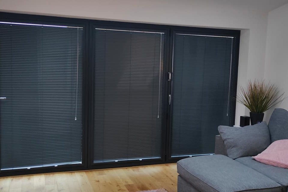 Picture of Living room with perfect fit blinds, soft furnishings, and dark blinds covering a large window.